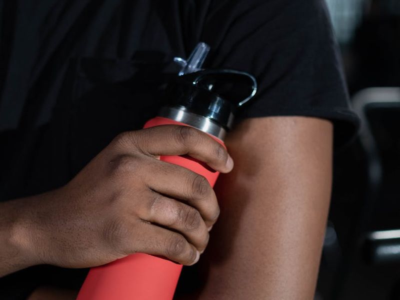 Close up of a person hands holding a water bottle after workout