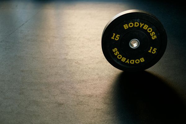 Minimalist home gym with a mat and some light weights